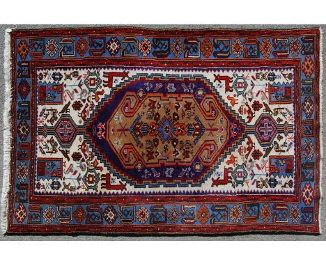 A mid 20th century Persian Islamic Hamadan handwoven wool carpet rug having a medallion to the centre with foliate motifs on 