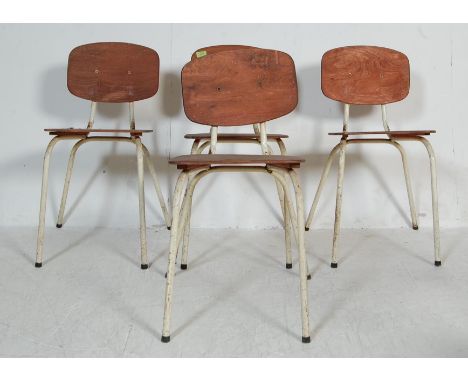 A set of four retro vintage 20th century stacking chairs having plywood back rests and seats raised on a tubular metal frames