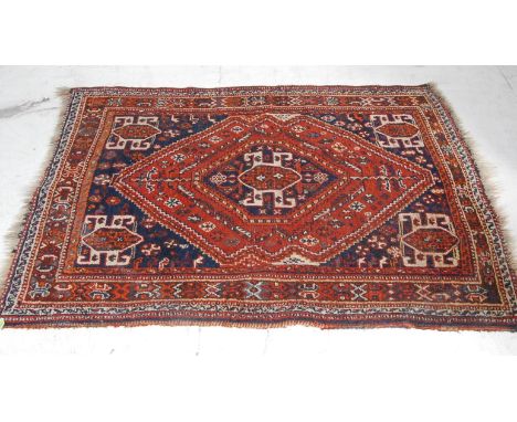 An early 20th century Persian Islamic Shiraz handwoven wool carpet rug. The rug having a large diamond medallion to the centr