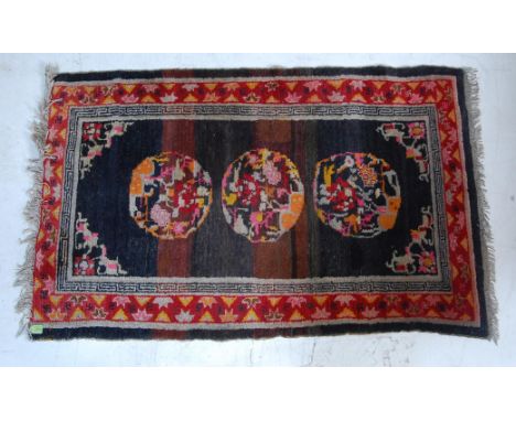 A decorative vintage 20th century handwoven Tibetan rug having three polychrome medallions set within a border having Hindu m