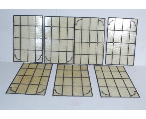 A set of vintage 20th century seven stained glass windows having lead lining in a 4x4 glass panel configuration in a yellow c