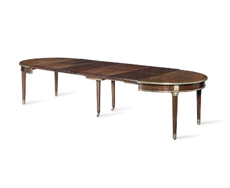 A Louis XVI ormolu and brass mounted acajou moucheté (plum pudding mahogany) extending dining tableCirca 1785, with four late