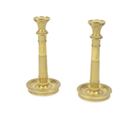 A pair of French Empire gilt bronze candlesticksCirca 1810the anthemion cast flared nozzles with detachable drip pans above m