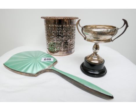 A silver framed and mint green enamel hand mirror, twin handled silver trophy cup and a silver plated bottle coaster 