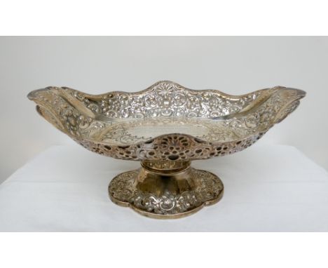 A Victorian oval silver basket on a pedestal foot embossed with flowers and foliage with inscription 'Presented to Dr & Mrs B