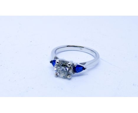 Sapphire and diamond three stone ring the central brilliant cut diamond weighing 1.06cts flanked each side with pear shaped s