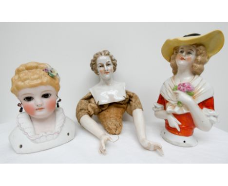 A group of three 19th century pin cushion half dolls, one bisque dolls head with glass eyes the other half bust with hands, t