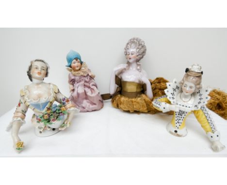 A group of four porcelain and bisque pine cushion half dolls modelled as 18th century ladies   All damaged