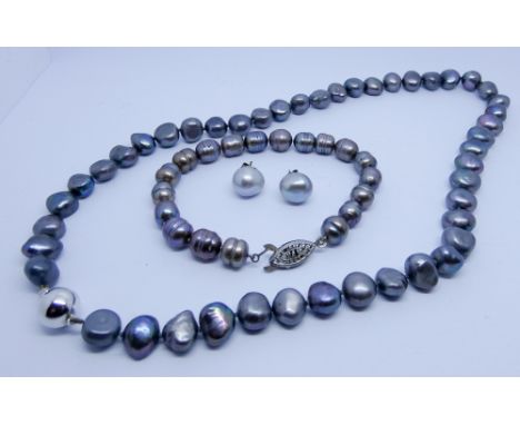 Row of grey freshwater pearls with 18ct white gold bead fastening, similar bracelet with white metal clasp and a pair of silv