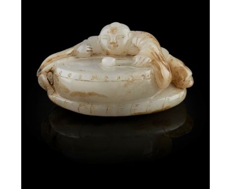 GREY JADE CARVING OF A BOY PLAYING A DRUM  the boy leaning against the oversized drum and striking it with a drumstick, the g