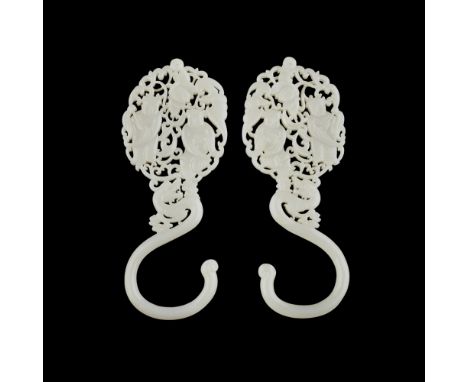PAIR OF WHITE JADE HOOKS  each hook issuing from a dragon head surmounted by a finely carved and pierced plaque depicting two