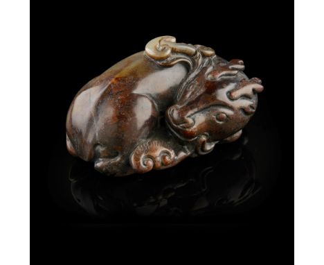 ARCHAISTIC GREEN AND RUSSET JADE CARVING OF A DEER  the stag in a recumbent position with the head turned backward and the mo