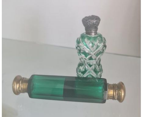 A green glass double end perfume bottle and one silver topped bottle.