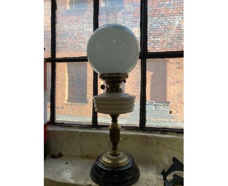A brass stem oil lamp and shade.