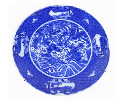A Chinese porcelain dish, late 19th century, decorated internally with a dragon and a phoenix fighting above the waves, surro