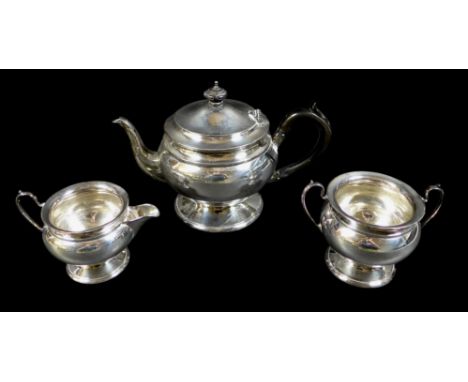 A George V silver three piece tea service, comprising teapot on circular foot, with ebonized handle, 25.5 by 14 by 16cm high,