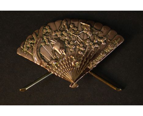 A Meiji period Shakudō ware gilt bronze miniature model of a Japanese fan with relief stork and blossom tree design, fixed to