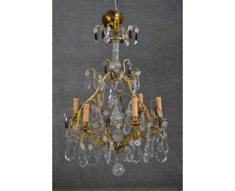 A large early 20th century gilt brass six branch chandelier with crystal flowers and swags studded with faceted purple glass 