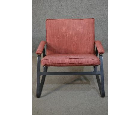 A pair of mid to late 20th century armchairs, purchased from Heal's, with a steel frame, upholstered in light red fabric to t