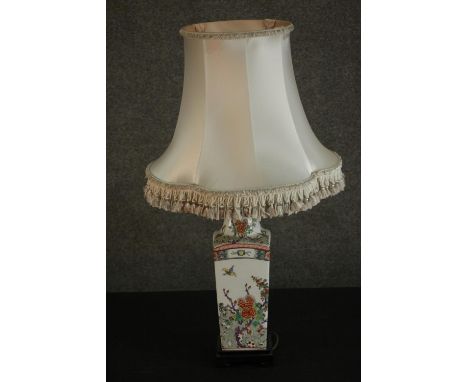 A table lamp in the form of a Chinese hand painted porcelain vase decorated with flowers and insects with a cream silk shade.