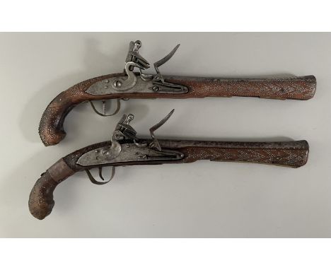 TWO INDIAN FLINTLOCK BLUNDERBUSS PISTOLS FOR THE TOURIST MARKET, LATE 19TH CENTURY almost forming a pair, with iron barrels r