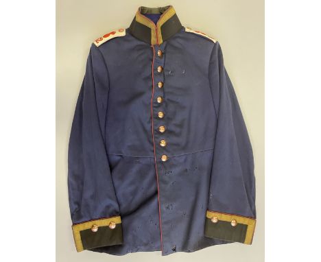 A SENIOR NCO’S BLUE FULL DRESS TUNIC OF GERMAN ARTILLERY with black cloth facings and scarlet piping, gold lace edging to col