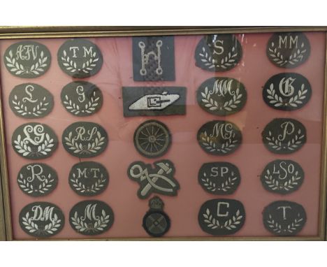 ARMY SPECIALIST BADGES a frame containing 25 arm-badges in white embroidered initials on khaki backing within laurel sprays, 