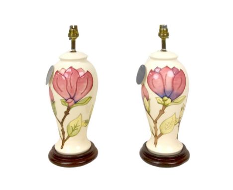 A pair of late 20th century Moorcroft magnolia pattern electric lamp bases, both 37cm high overall. (2)In need of re-wiring. 