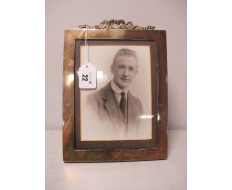 A Hallmarked Silver Mounted Rectangular Photograph Frame, London 1917, of plain design with tied ribbon detail, on wooden eas