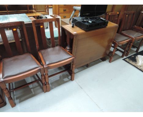 A mid 20th Century oak gate leg dining table and four stained frame chairs