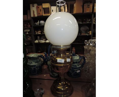 A traditional brass oil lamp with opaque glass shade