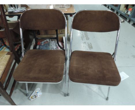 A pair of vintage folding chrome frame chairs