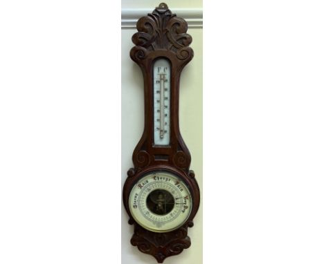 An oak cased barometer with a craved cresting above an mercury thermometer and an insight movement