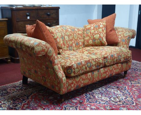 A Victorian style camel back sofa, raised on turned legs and castors. 212cm L x 85cm H x 100cm W 