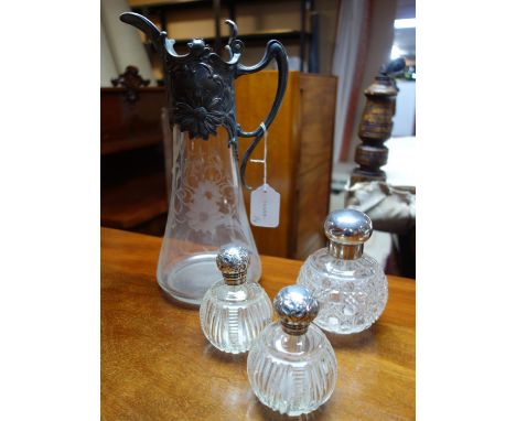 A pair of Victorian glass scent bottles with silver tops, together with a larger example by Mappin &amp; Webb and an Art Nouv