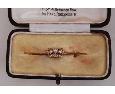 A boxed 14ct gold Naval bar brooch with seed pearl encrusted crown with safety catch. Bar and crown marked 14ct. Weight 2.9g.
