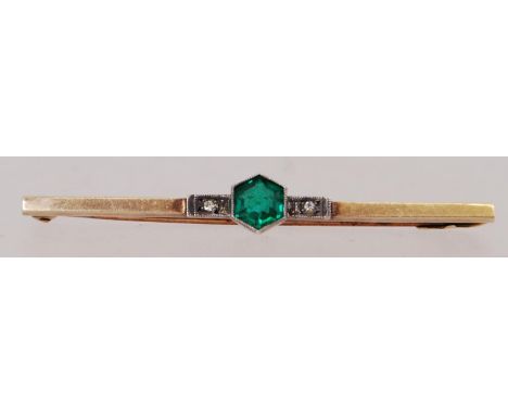 A 9ct gold Art Deco bar brooch  with a green silver set central stone. Measures 5cms. weight 1.6g. Marked 9ct silver set. Tes