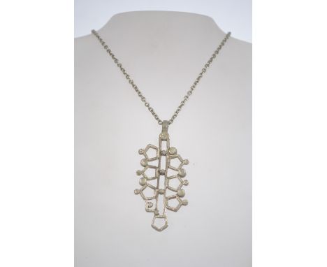 A 1970's brutalist silver tone metal pendant on a chain. The chain is 6.7cm and the pendant is 6.5cm.