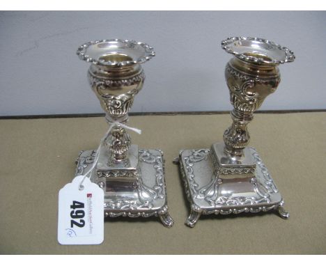 A Pair of Highly Decorative Hallmarked Silver Candlesticks, each allover detailed in relief, with removal nozzle, raised on s