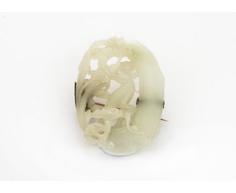 A late 19th Century Chinese jade brooch, the oval carved and pierced light coloured hardstone panel with a bird amongst scrol