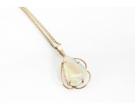 A white opal drop pendant, the pebble shaped stone in a four claw setting marked 9K on a curb link chain, 6.1g 