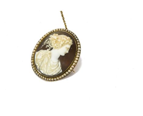 A 19th Century shell cameo on gold mount, with seed pearl frame, the oval cameo carved depicting  a portrait of a young class