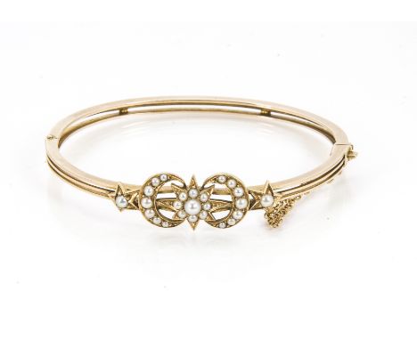 A Victorian gold and seed pearl bangle, having crescent and star design set with small white pearls on hinged three band bang