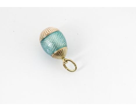 A Russian Henrik Wigstrom gold and enamel egg, the guilloche green body with ribbed lower and upper section, marked to bale, 