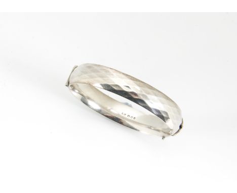 A contemporary heavy silver bangle, hinged clasp with adzed decoration, dated 1964 
