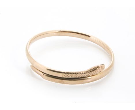 An early 20th Century 9ct gold serpent bangle, by Saunders and Shepherd, with engraved head and scales, tail af, 13g 