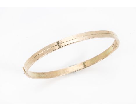 A 1970s Middle Eastern gold bangle, hinged with single line to centre, marked 14k, 22.2gBox clasp has had some work. It works