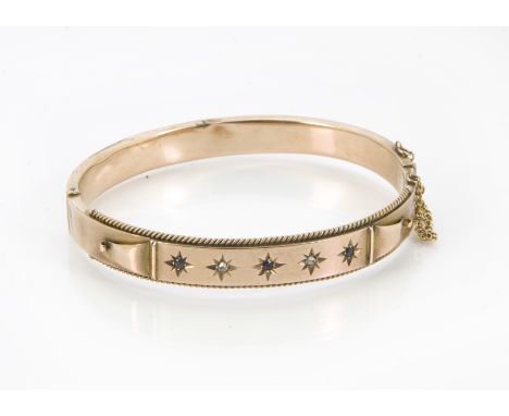 A Victorian gold bangle, one half with rope twist edging and tablet set with sapphires and diamonds, with safety chain, 10.6g