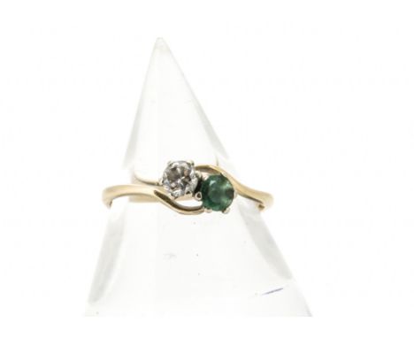 An emerald and diamond 14ct gold crossover ring, the claw set circular cut stones in white metal on a yellow metal shank mark