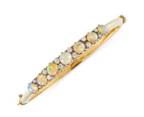 AN ANTIQUE OPAL AND DIAMOND BANGLE in yellow gold, set with a row of seven graduated cabochon opals punctuated by pairs of ol